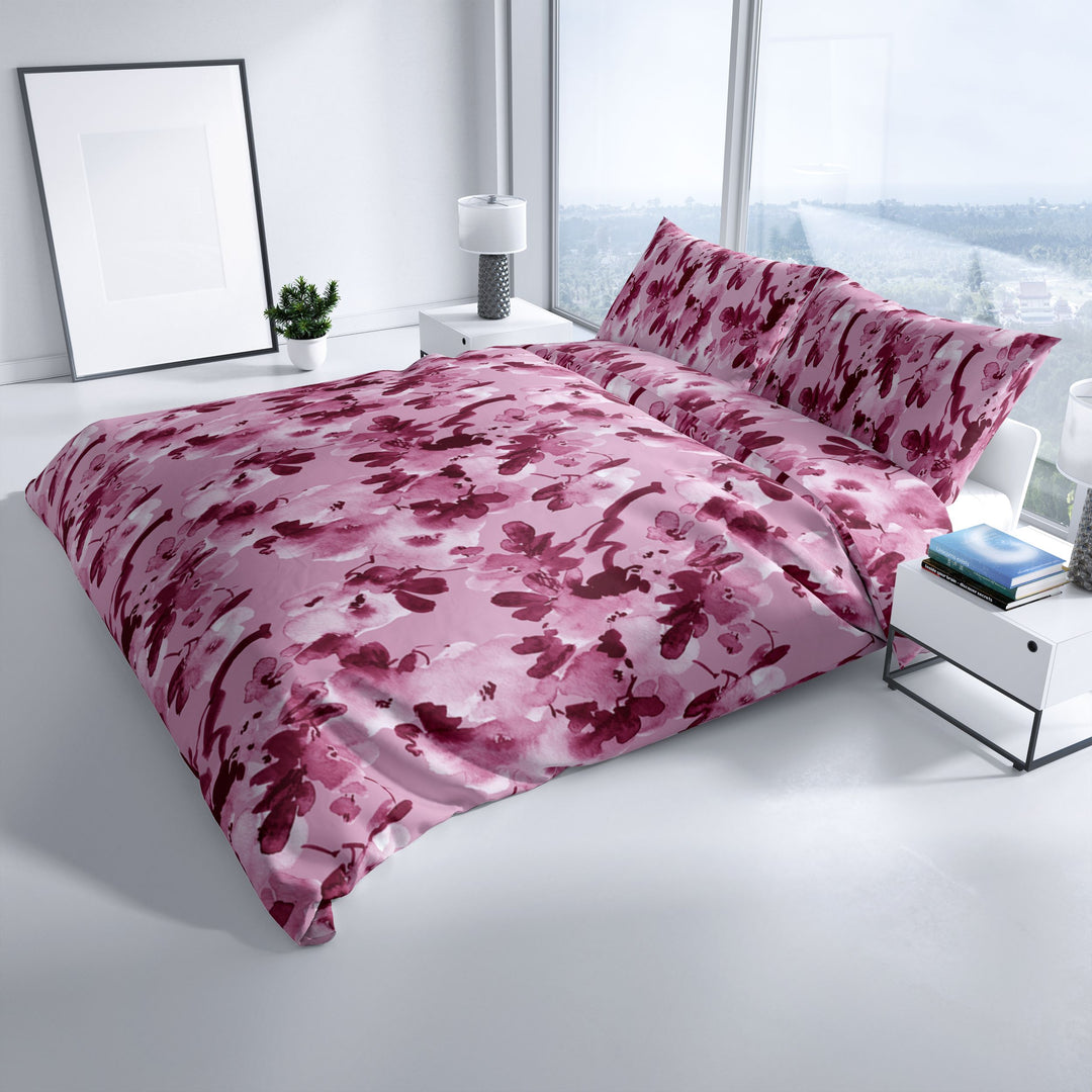 Florale Bettwäsche in Rosa und Bordeaux auf einem Doppelbett mit großer Fensterfront – stilvolle Schlafzimmerdekoration.