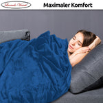 Entspannende Szene mit Frau unter der dunkelblauen Kuscheldecke auf dem Sofa – ideal für kalte Tage.