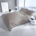 Grau Bettwäsche mit feiner Struktur auf einem Doppelbett in modernem, hellen Schlafzimmer mit Nachttisch und Dekoration.“