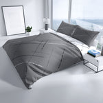 Grau-weiße Baumwoll-Wendebettwäsche mit Linienmuster auf einem modernen Bett im hellen Schlafzimmer – pflegeleicht und hautfreundlich